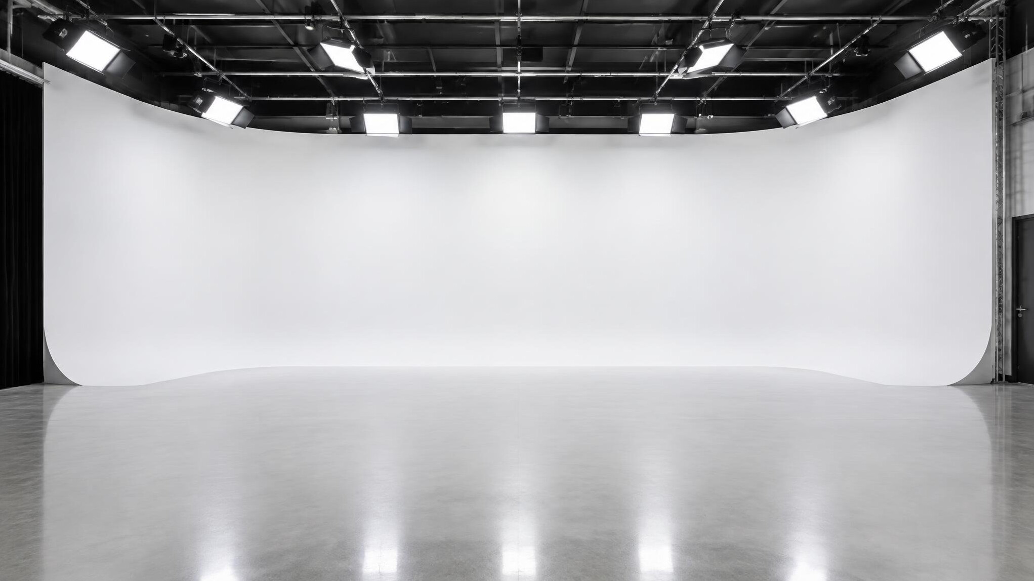 Empty studio with curved cyclorama wall and lighting grid